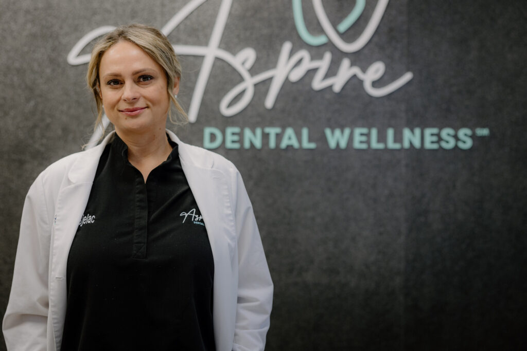 Dr. Sladjana Bjelac in front of the Aspire Dental Wellness sign