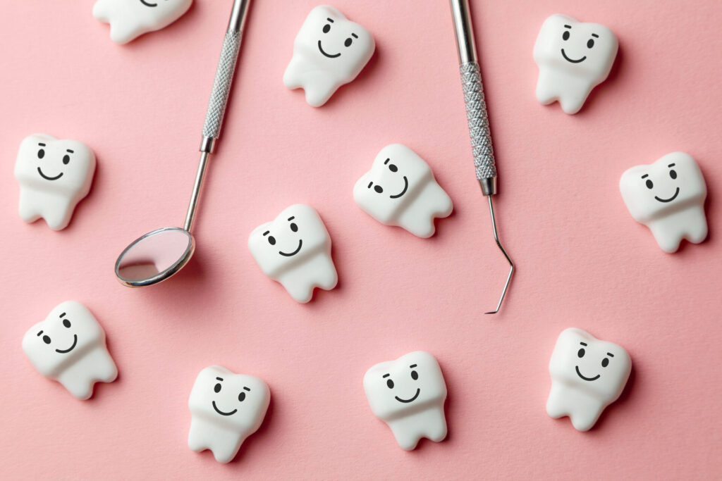 Model teeth and dentist's tools on a pink background