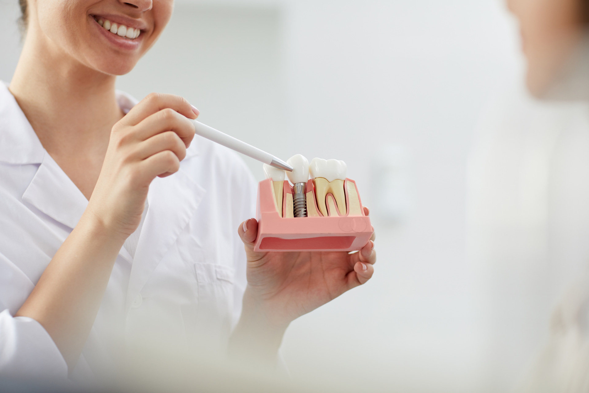 A dentist explaining different types of implants to a patient