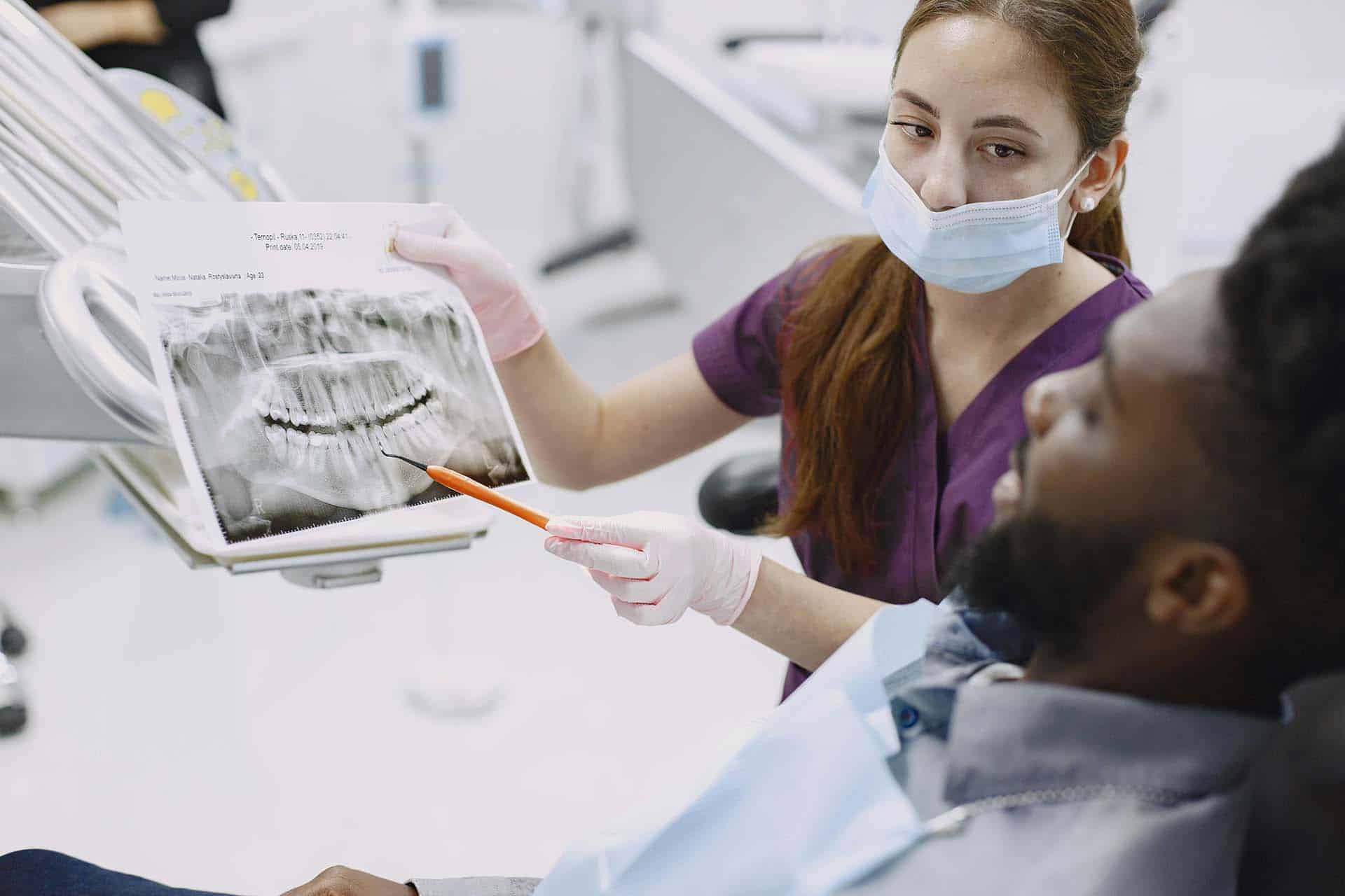 A dentist explaining using an x-ray to explain to a patient