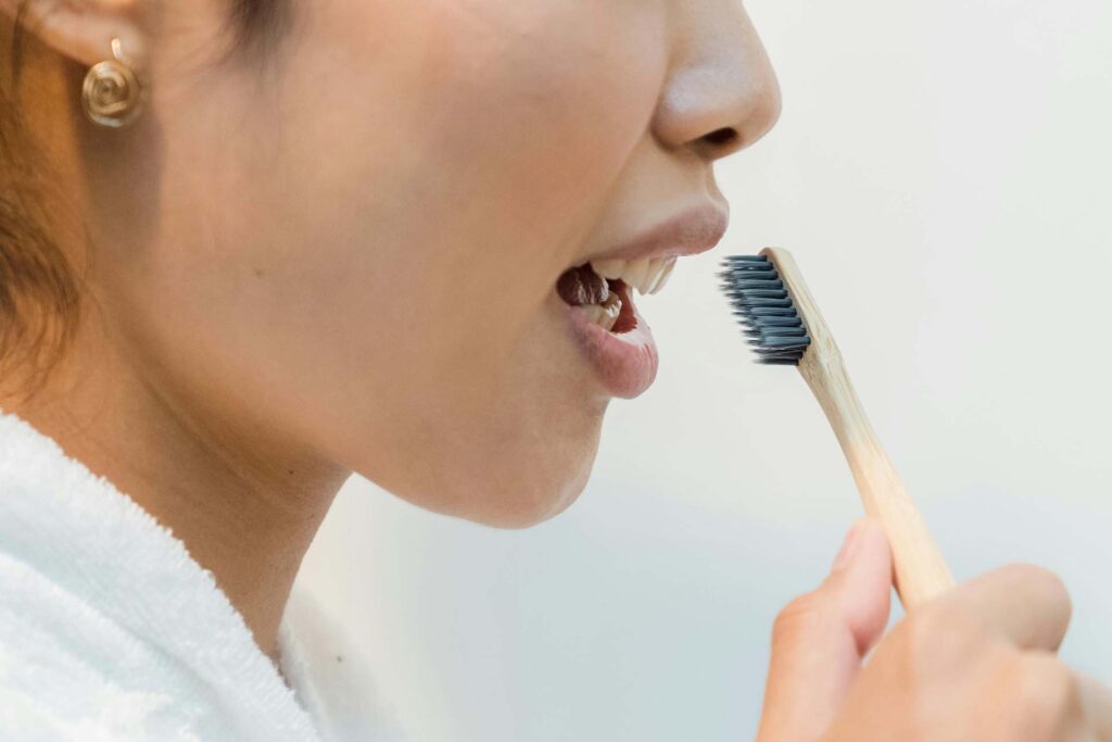 A woman starting to brush her teeth