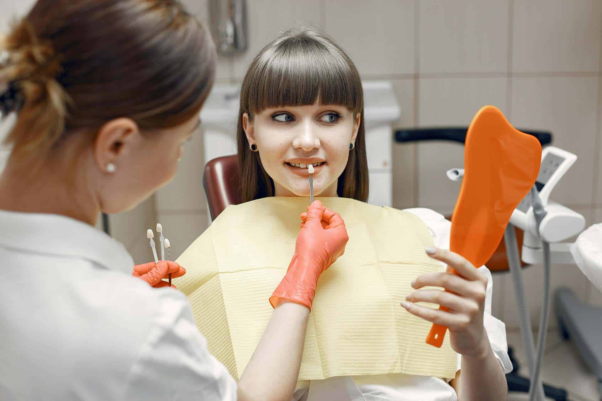 Dentist testing different enamel shades on a girl