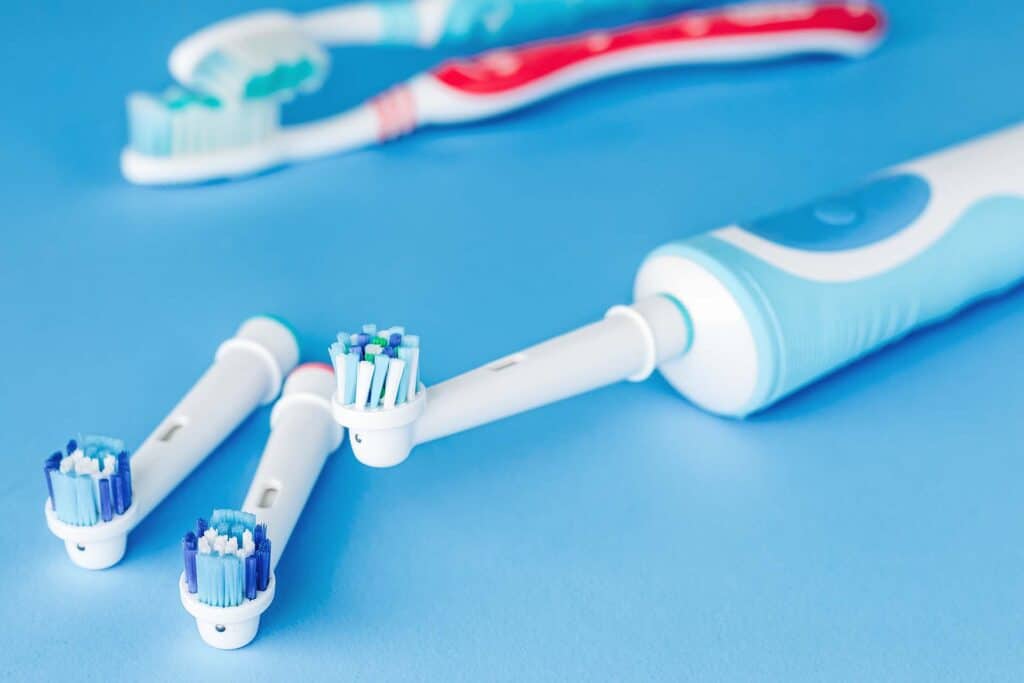Electric and manual toothbrush  on blue background, close up
