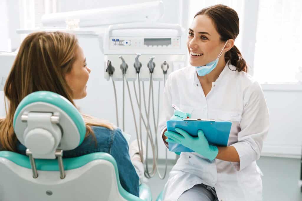 dentist woman smiling while working with patient in dental clinic