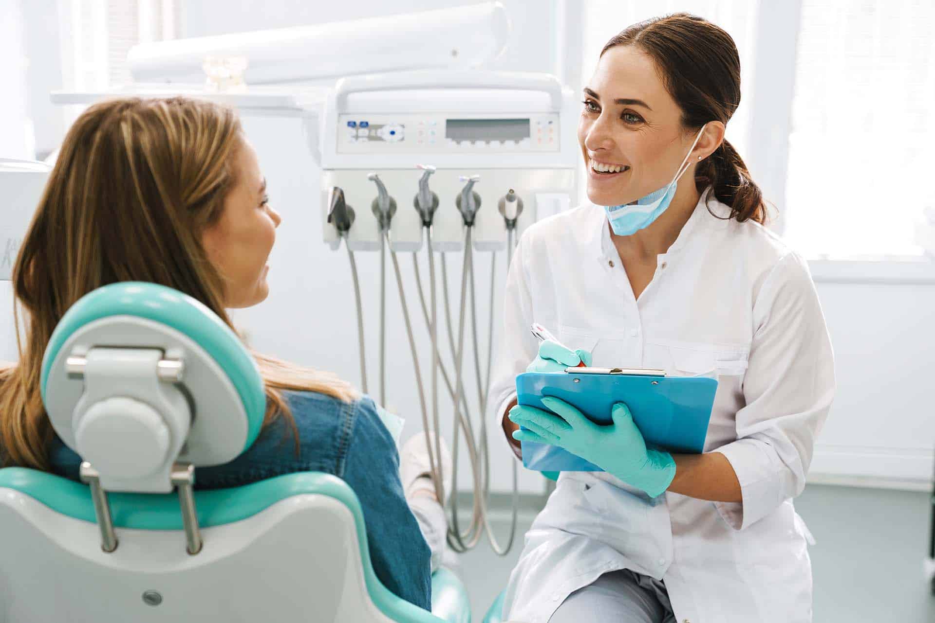 dentist woman smiling while working with patient in dental clinic