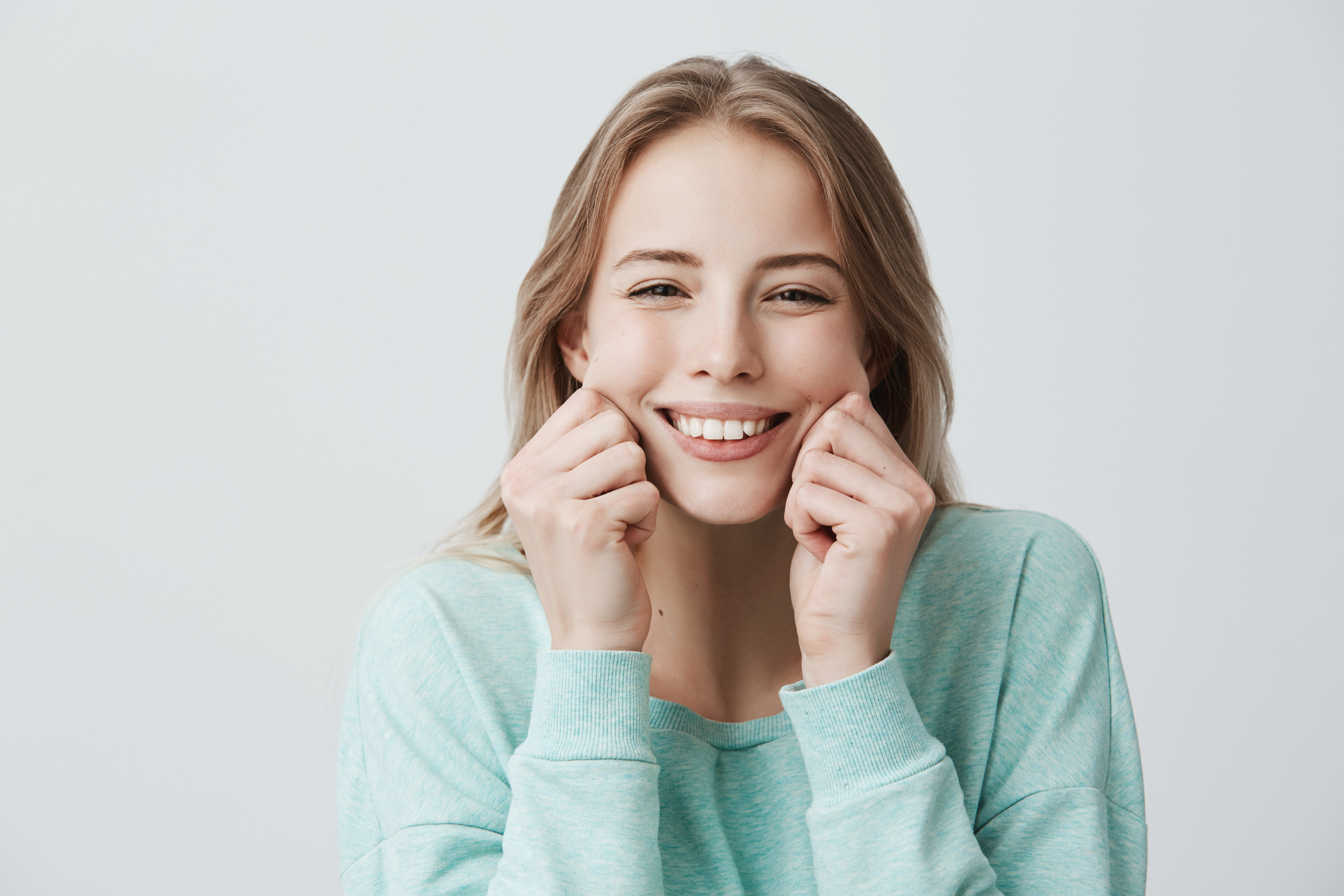 Smiling woman with healthy teeth and balanced gums, representing a confident and well-proportioned smile