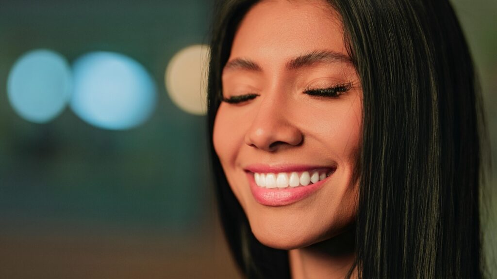 Young woman smiling with bright white teeth after professional teeth whitening