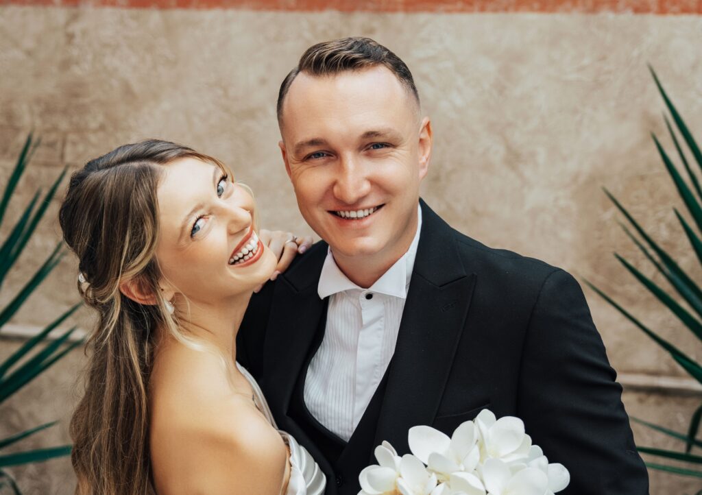 Bride and groom smiling with healthy wedding teeth during wedding portraits.
