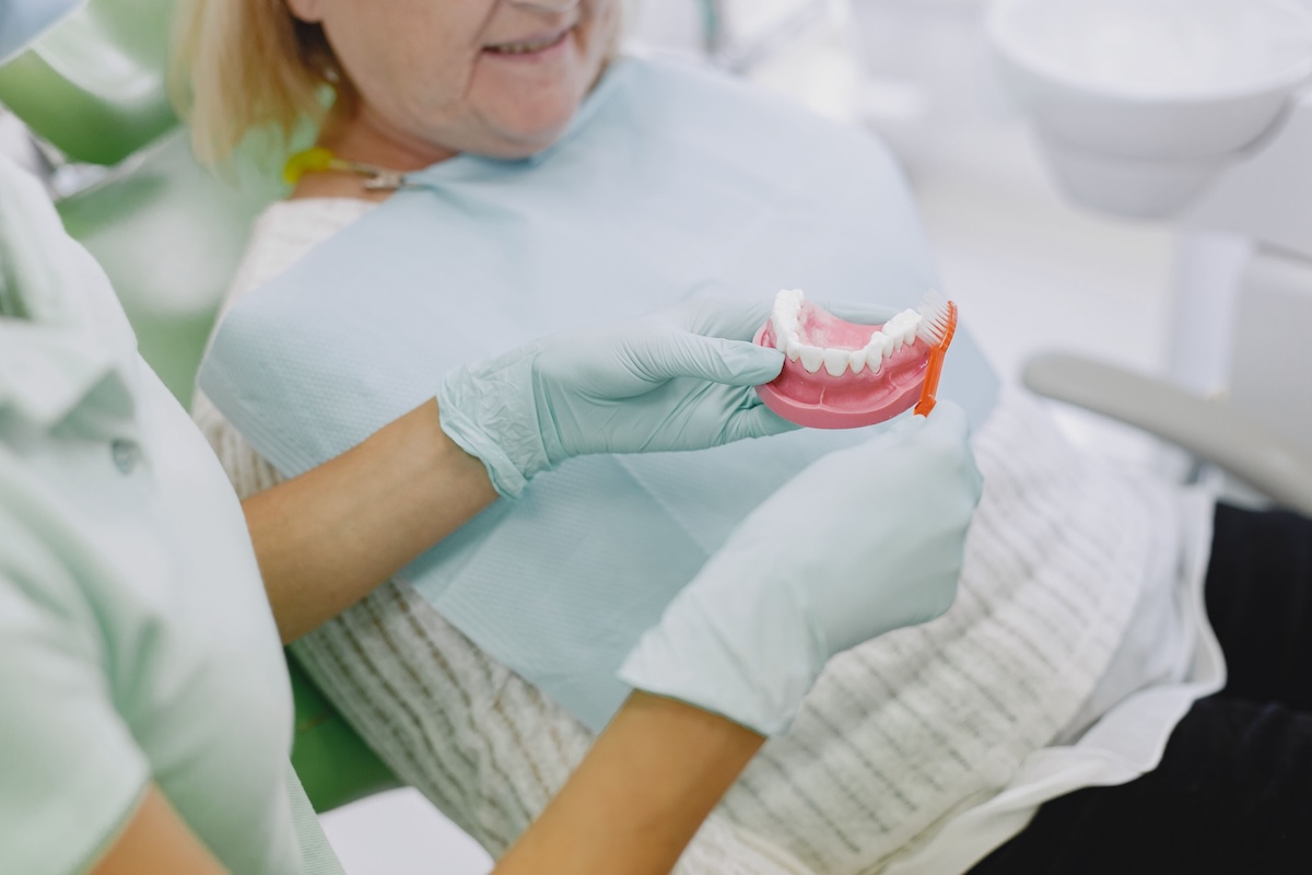 Dentist showing patient a denture model during consultation