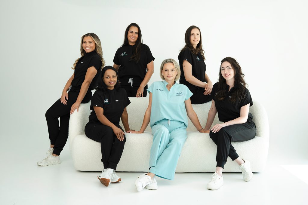 Dr. Bjelac and her team sitting on a sofa in their uniforms.